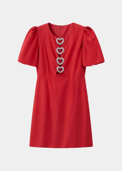 Robe courte à pois avec nœuds, manches bouffantes, en tissu léger idéal pour une soirée, offrant une allure féminine et chic.