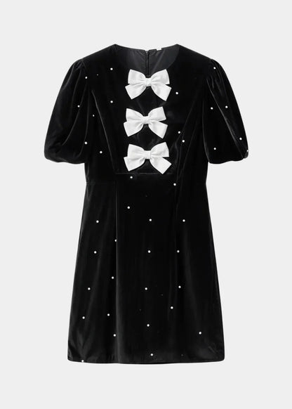 Robe courte à pois avec nœuds et manches bouffantes, en tissu léger, parfaite pour les soirées d'été.
