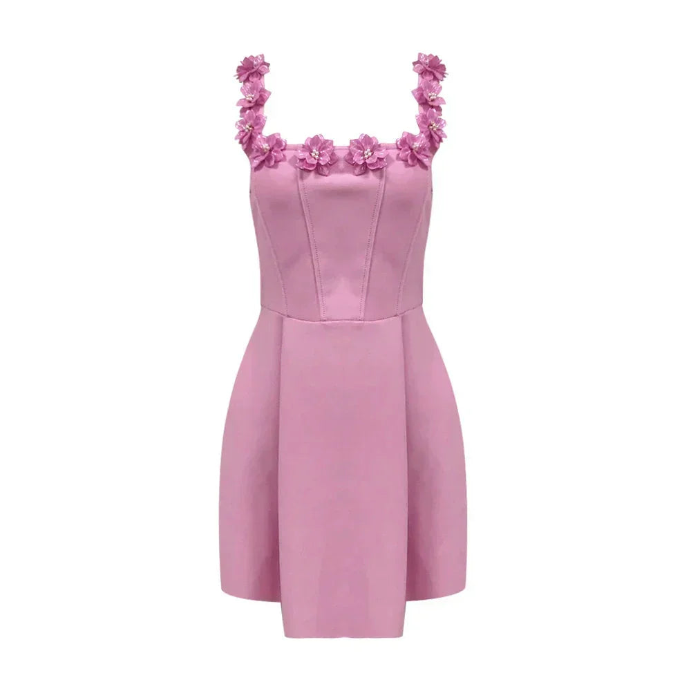 Robe courte rose sans manches avec encolure florale, en tissu léger, idéal pour les fêtes d'été. Détails floraux délicats.