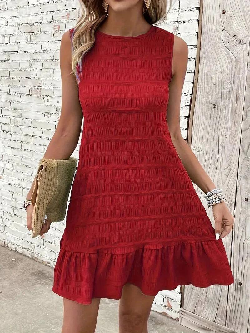 Robe courte sans manches en tissu texturé, avec ourlet évasé, idéale pour les journées d'été décontractées.