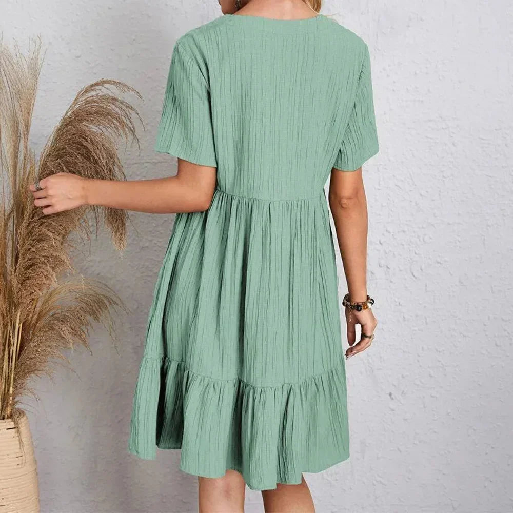 Robe courte en coton léger avec volant, col en V et manches courtes, idéale pour les journées d'été décontractées.