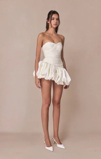 Robe de soirée femme en tissu drapé, style ballon, avec manches délicates et ceinture accentuant la taille.