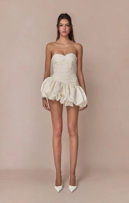 Robe de soirée femme en ivoire, drapée avec une coupe ballon, en tissu léger pour un look élégant et fluide.
