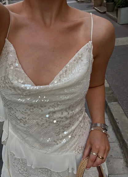Robe d'été femme blanche ornée de sequins, en tissu léger, avec une coupe fluide et manches courtes.