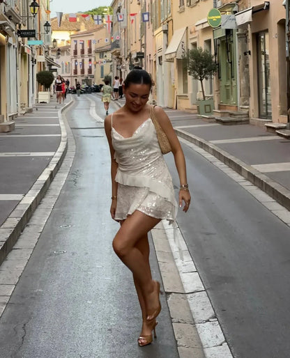 Robe été blanche pour femme, ornée de sequins, en tissu léger avec des bretelles fines et une coupe estivale fluide.