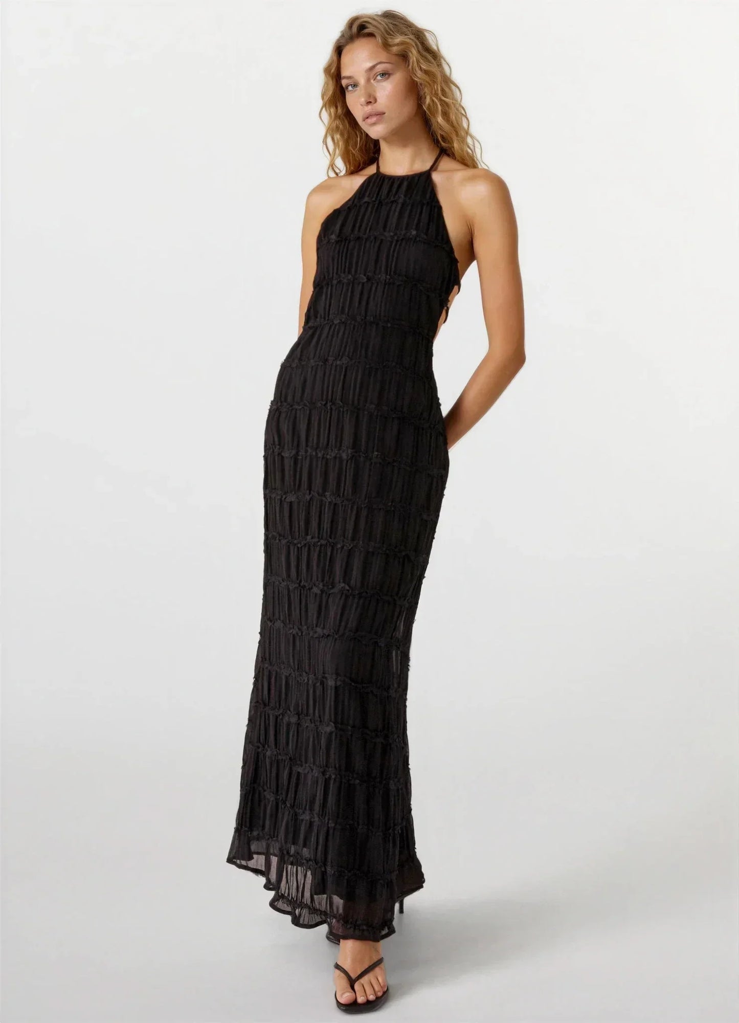 Robe d'été femme noire, dos nu avec texture légère, idéale pour les journées chaudes et les sorties décontractées.