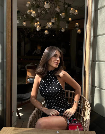 Robe d'été noire à pois blancs, en coton léger, avec des manches courtes et une taille cintrée pour un look décontracté.