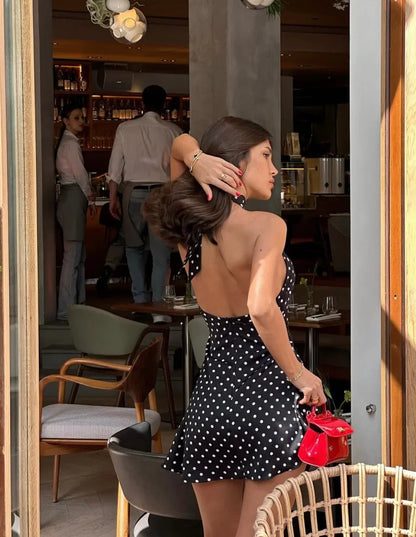 Robe d'été noire à pois pour femme en coton léger, avec bretelles fines et jupe fluide. Idéale pour les journées estivales.