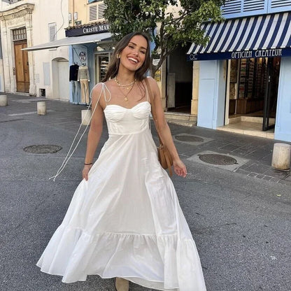 Robe longue blanche à bretelles fines, en coton léger, avec buste froncé et jupe fluide, idéale pour l'été.