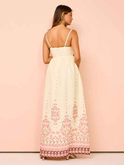 Robe longue blanche en tissu léger avec motifs floraux, ourlet détaillé et bretelles fines idéale pour l'été.