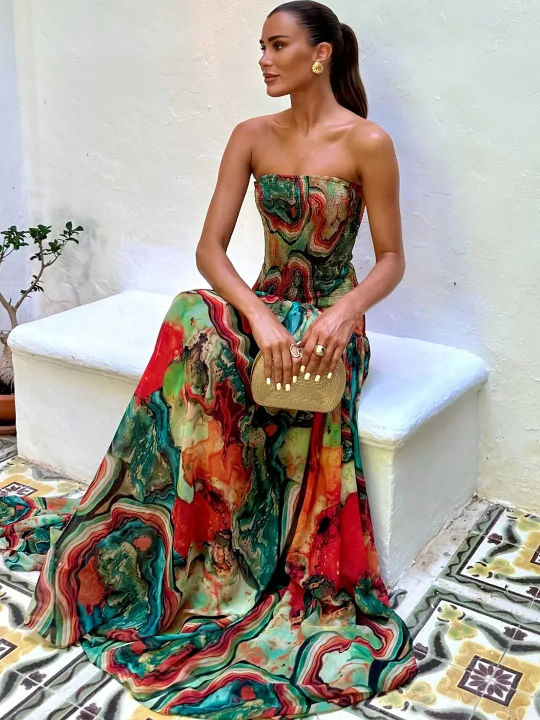 Robe longue femme à buste dénudé, en tissu léger avec imprimé multicolore et coupe fluide, idéale pour les journées d'été.