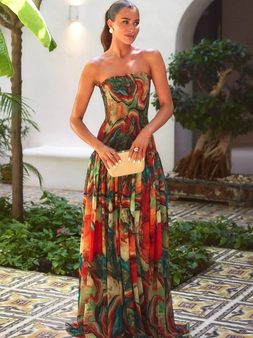 Robe longue imprimée multicolore avec buste dénudé, en tissu léger et fluide, idéale pour des occasions décontractées.