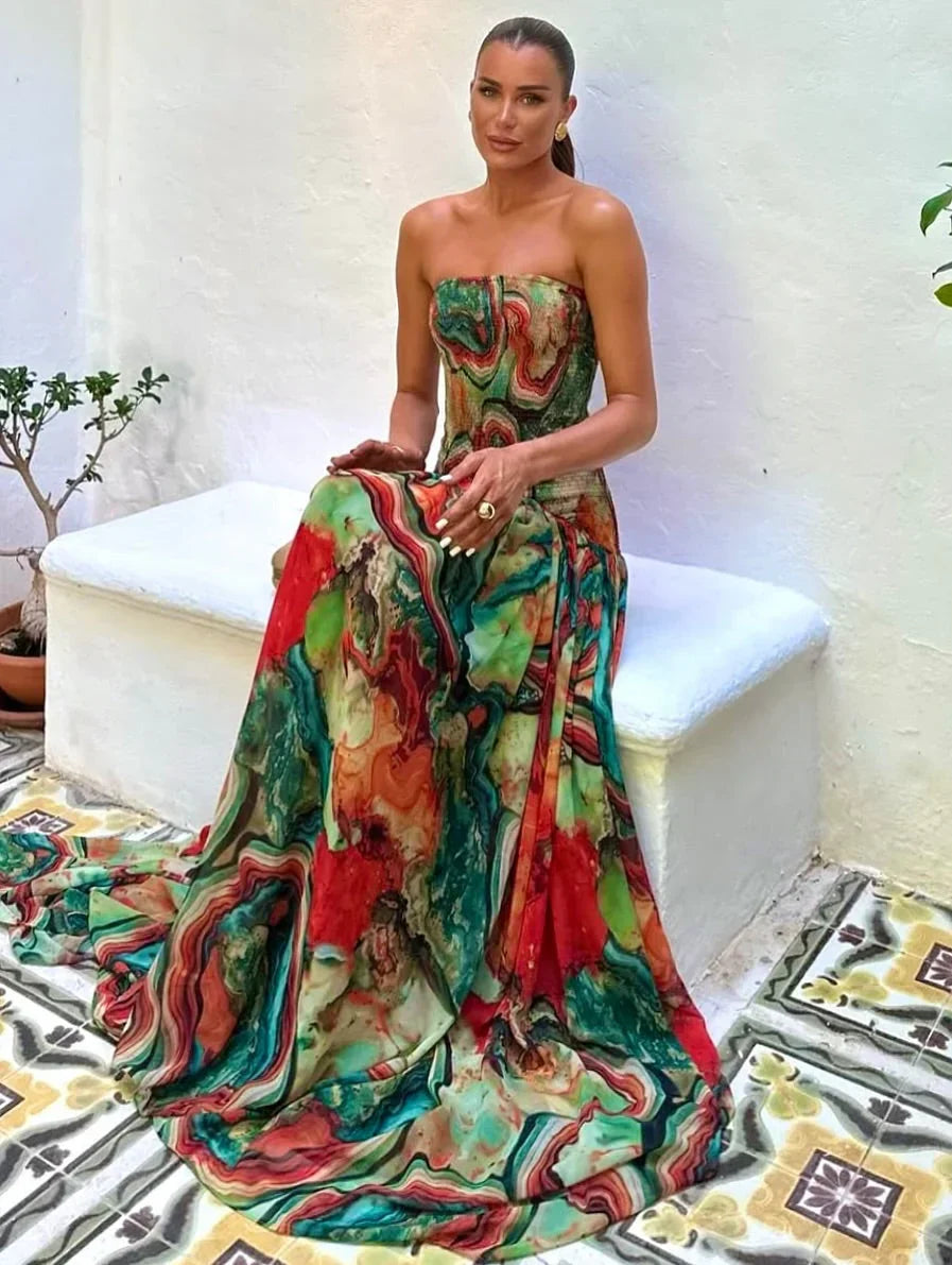 Robe longue buste dénudé en tissu léger avec imprimé multicolore et détails fluides, parfaite pour les occasions estivales.