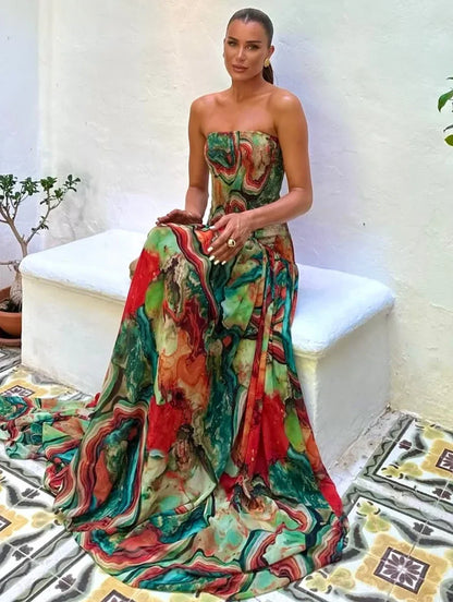 Robe longue buste dénudé en tissu léger avec imprimé multicolore et détails fluides, parfaite pour les occasions estivales.