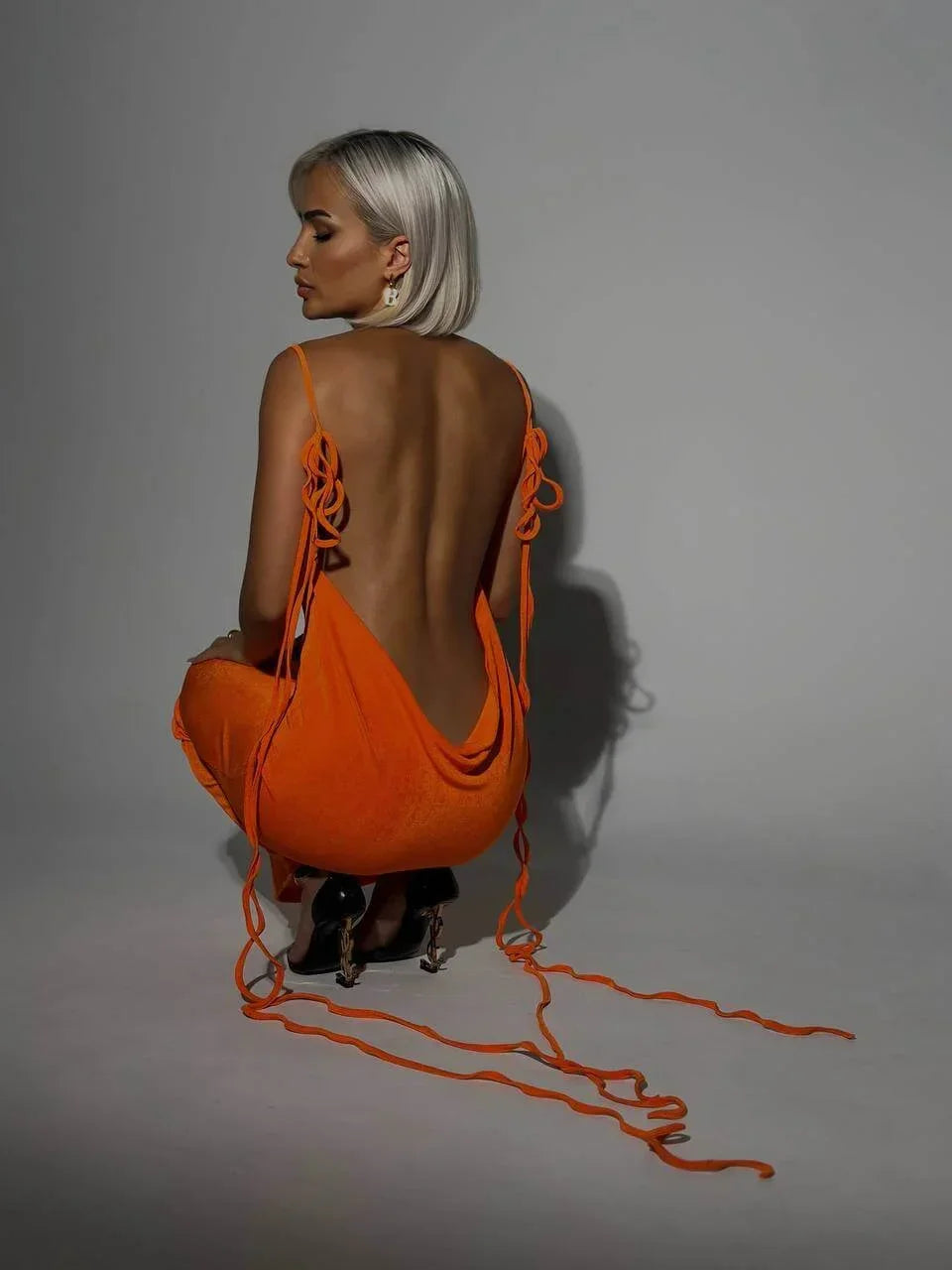 Robe longue dos nu ajustable en tissu léger, offrant des liens élégants pour un ajustement personnalisé lors des soirées.