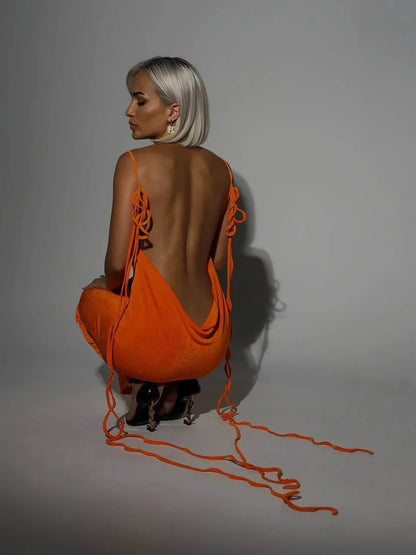 Robe longue dos nu ajustable en tissu léger, offrant des liens élégants pour un ajustement personnalisé lors des soirées.