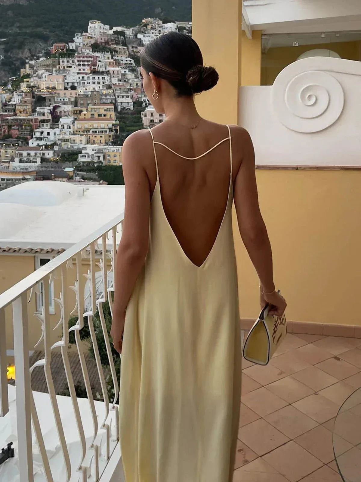 Robe longue jaune en tissu léger, dos nu avec fines bretelles, idéale pour les journées d'été ensoleillées.