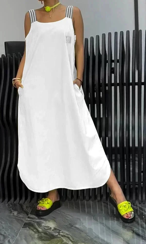 Robe longue blanche avec bretelles larges, en tissu léger, dotée de poches pratiques sur les côtés pour un style décontracté.
