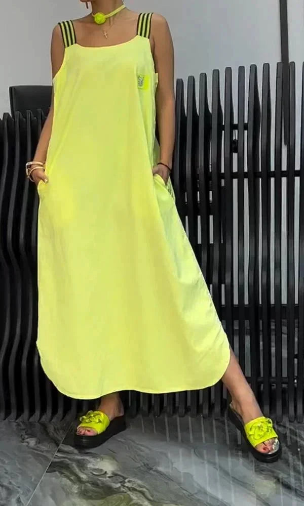 Robe longue jaune à bretelles larges, en tissu léger, dotée de poches pratiques et d'une coupe fluide.