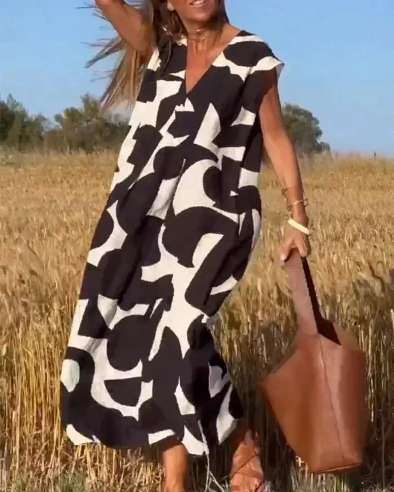 Robe longue féminine noire, col V, en tissu fluide avec motifs élégants, idéale pour un look décontracté et stylé.