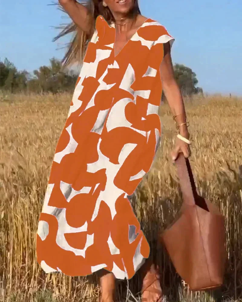 Robe longue orange pour femme avec col V, motifs fluides et tissu léger, idéale pour les journées chaudes d'été.