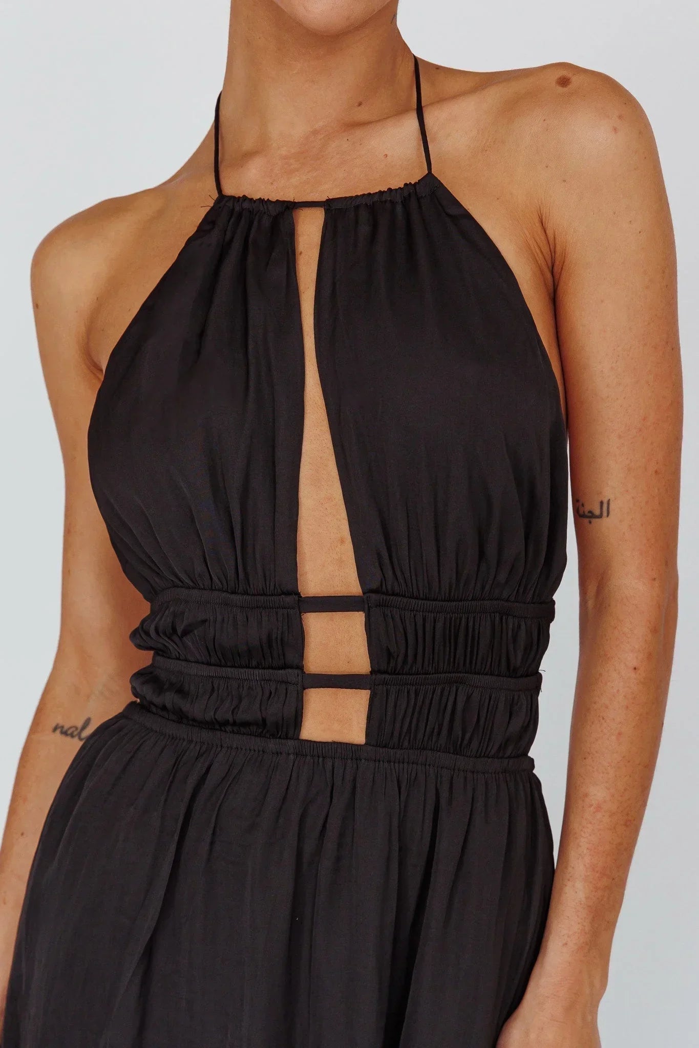 Robe longue femme en tissu léger, dos nu, avec découpes élégantes sur les côtés pour une silhouette moderne.