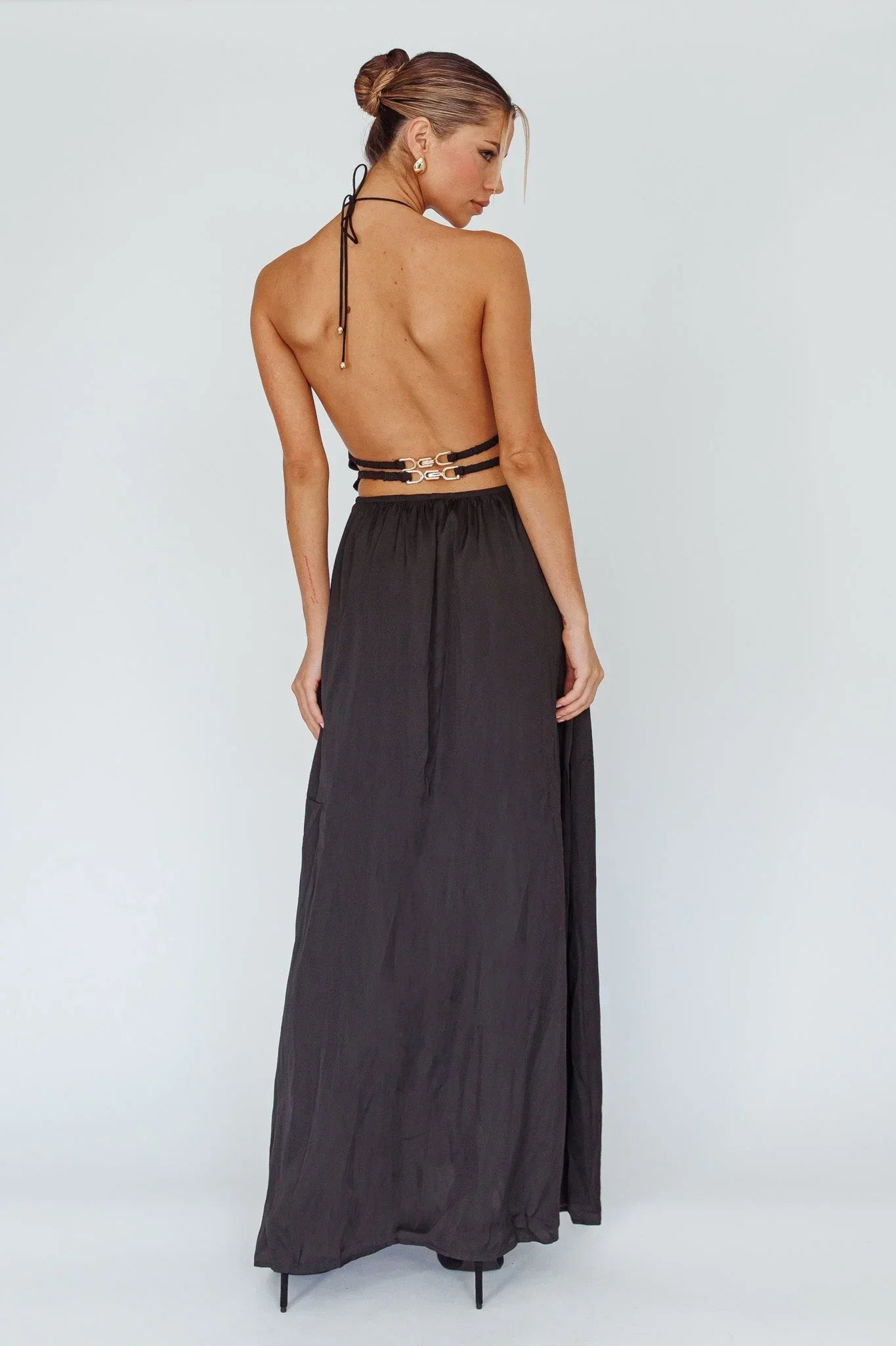 Robe longue pour femme en tissu léger, avec dos nu et détails découpés pour une touche d'élégance moderne.