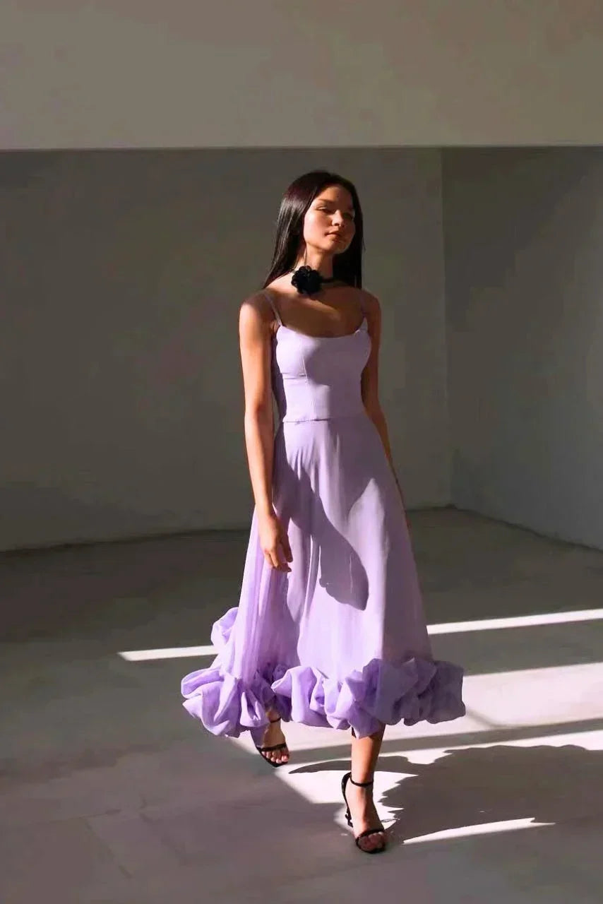 Robe longue femme en tissu léger, volants à l'ourlet, fines bretelles et coupe fluide pour un look élégant.