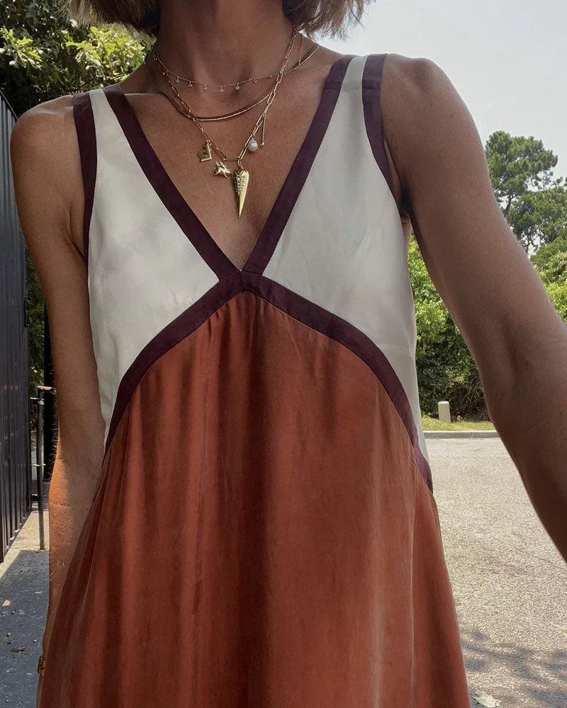 Robe longue bicolore sans manches avec col en V, confectionnée en tissu léger, parfaite pour les journées estivales.