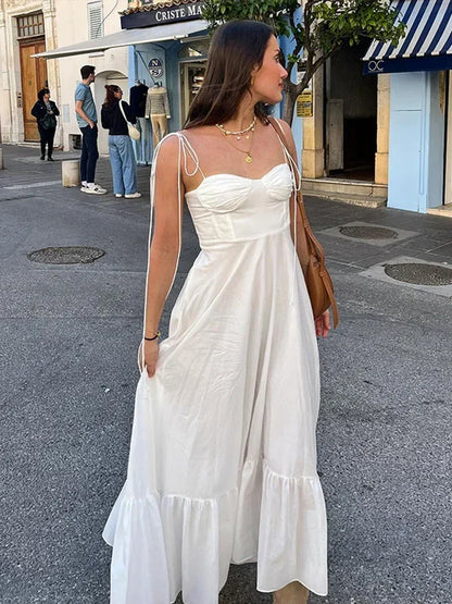 Robe longue blanche pour femme, en coton léger, avec bretelles fines et un décolleté en V. Parfaite pour l'été.