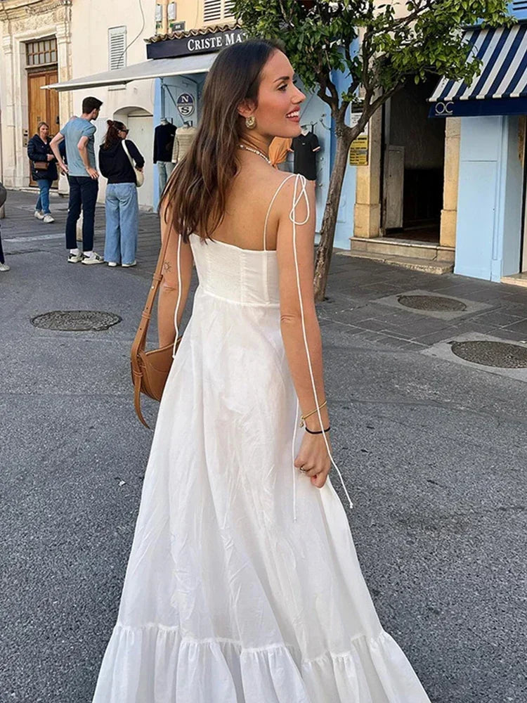 Robe longue femme blanche à bretelles fines en coton léger, avec une coupe fluide et un décolleté élégant.