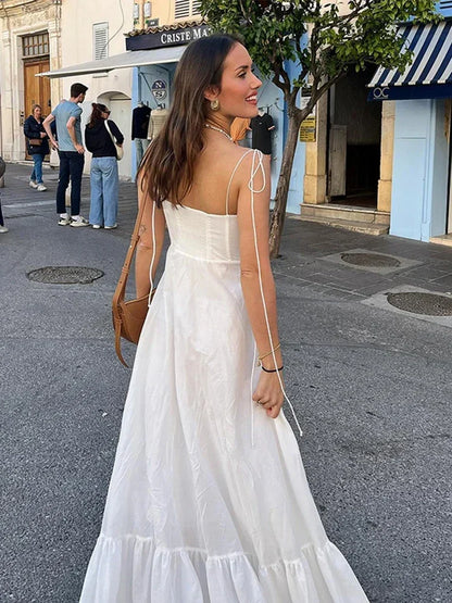 Robe longue femme blanche à bretelles fines en coton léger, avec une coupe fluide et un décolleté élégant.
