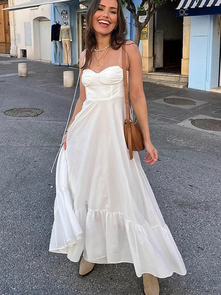 Robe longue blanche pour femme, fabriquée en coton léger, avec bretelles fines et un design fluide adapté à l'été.