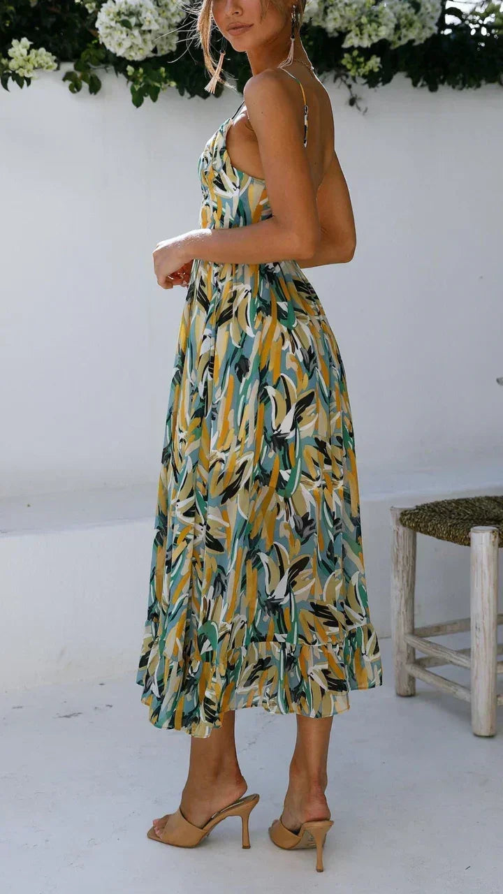 Robe longue femme à bretelles fines, en tissu léger, avec un imprimé végétal coloré et une coupe fluide.