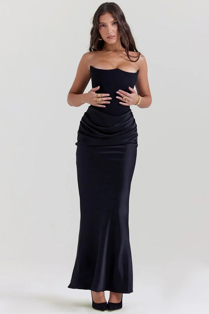 Robe longue femme en noir, confectionnée en tissu fluide, avec bustier drapé et ajustement élégant à la taille.