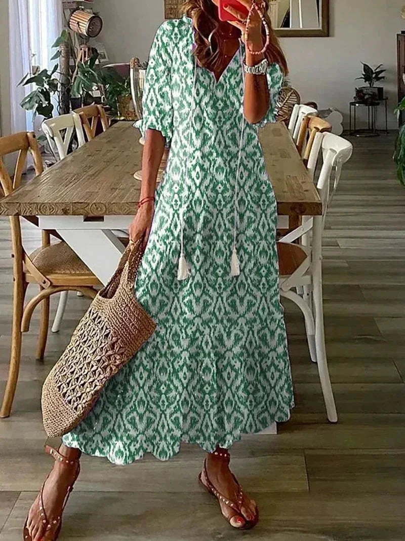 Robe longue en vert, col en V, motifs floraux, tissu léger, parfaite pour les occasions estivales.