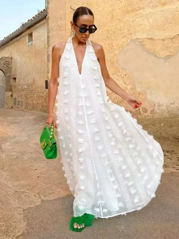 Robe longue femme en tissu léger, col halter, avec des détails floraux délicats pour un style féminin et élégant.