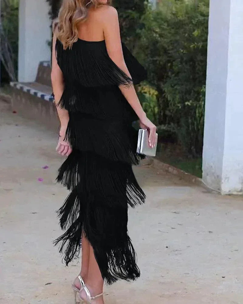 Robe longue femme en tissu léger avec franges et encolure asymétrique, idéale pour une soirée estivale.