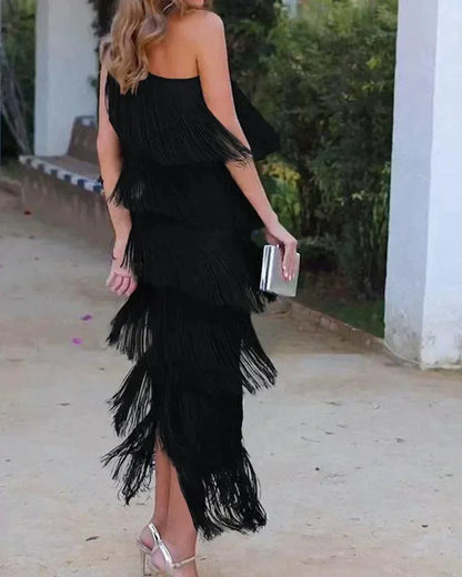 Robe longue femme en tissu léger avec franges et encolure asymétrique, idéale pour une soirée estivale.