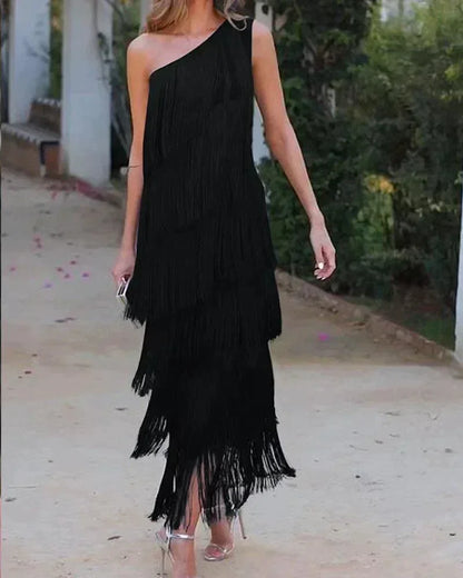 Robe longue femme en noir avec franges et encolure asymétrique, en tissu léger et fluide pour un look élégant.