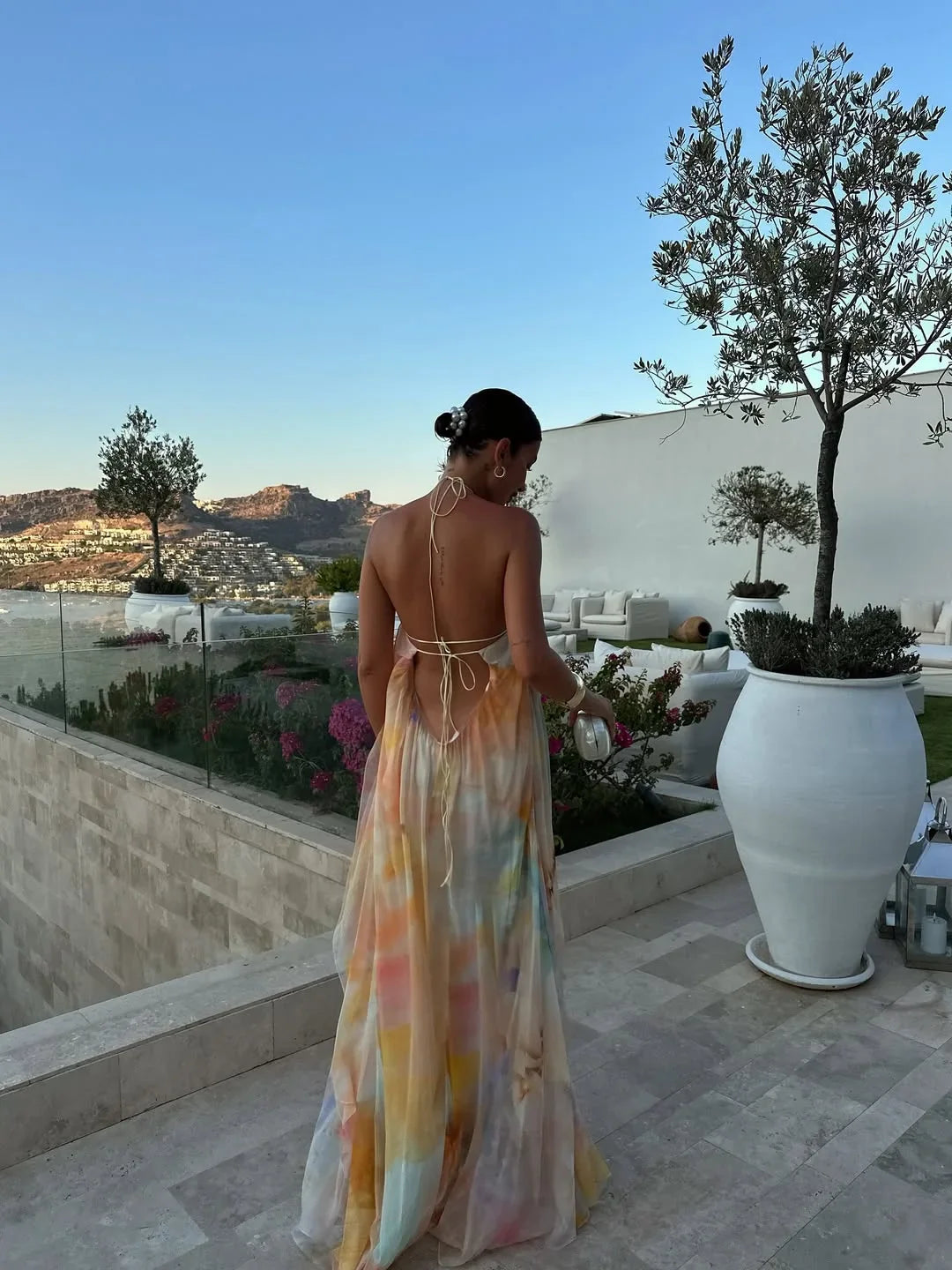 Robe longue femme imprimée, en coton léger, avec un élégant dos nu et des motifs floraux colorés pour un look estival.