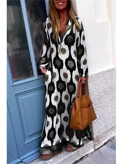 Robe longue noire à manches longues, col V, en tissu fluide avec imprimé floral, parfaite pour un look décontracté.