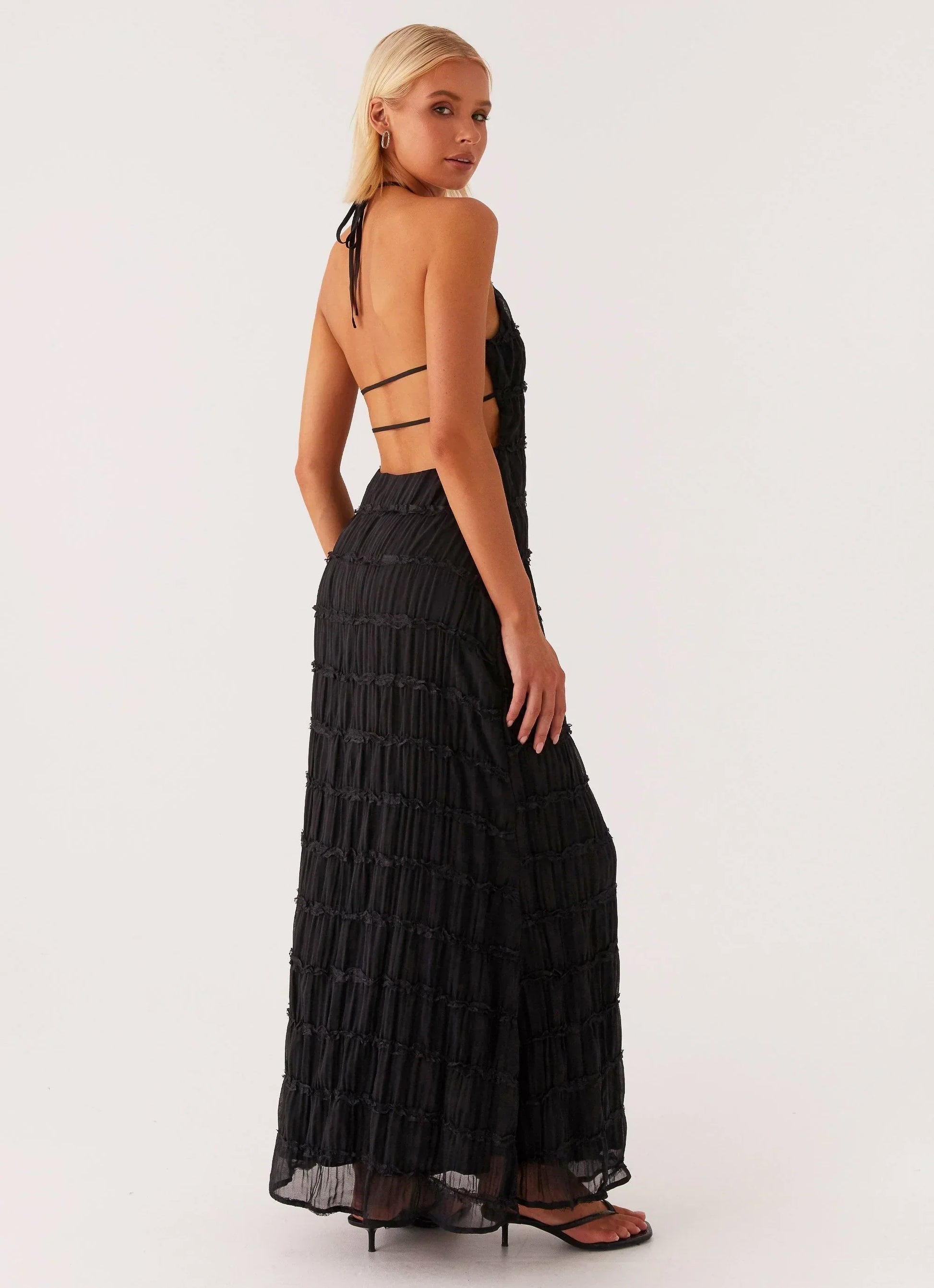 Robe longue noire à bretelles, en tissu doux, avec une coupe fluide et une taille cintrée pour un look élégant.