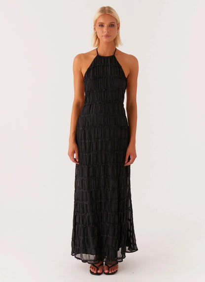 Robe longue noire à bretelles en tissu léger, silhouette fluide avec une coupe élégante et un design minimaliste.
