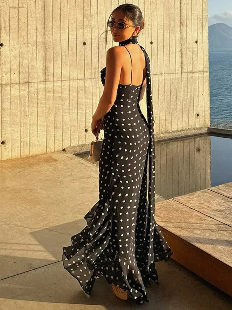 Robe longue noire à pois, en tissu léger, avec un décolleté élégant et une taille cintrée pour un look féminin.