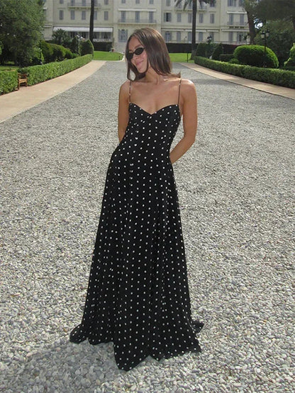 Robe longue noire à pois, en tissu léger, avec une coupe fluide et des manches courtes pour un style décontracté.