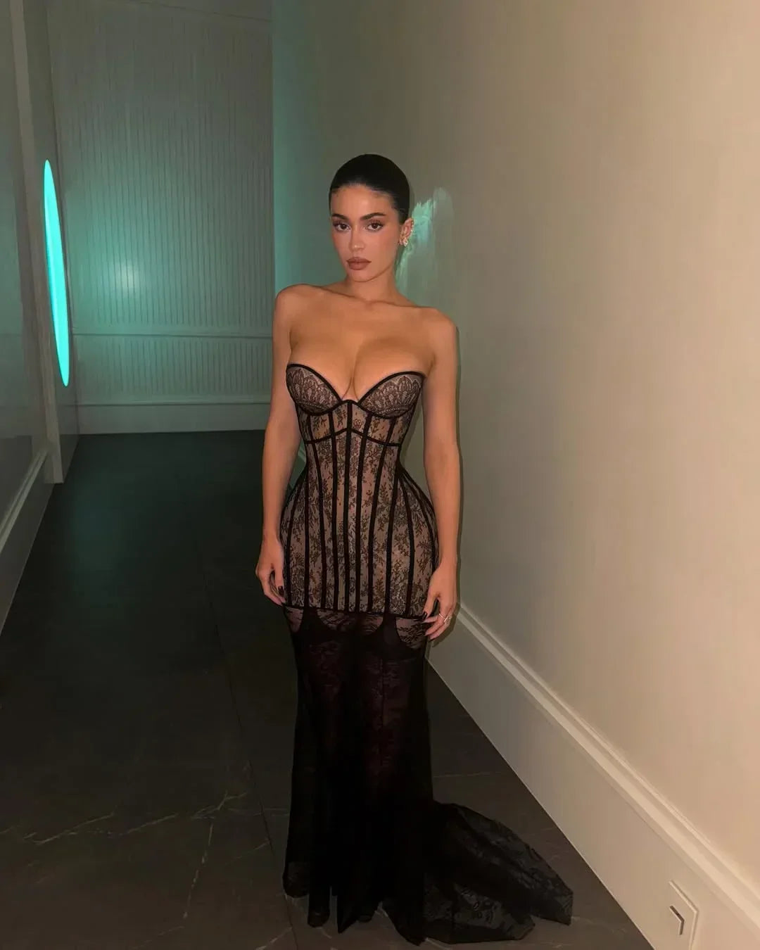 Robe longue noire pour femme avec bustier en dentelle, embelli de détails délicats et une coupe fluide élégante.