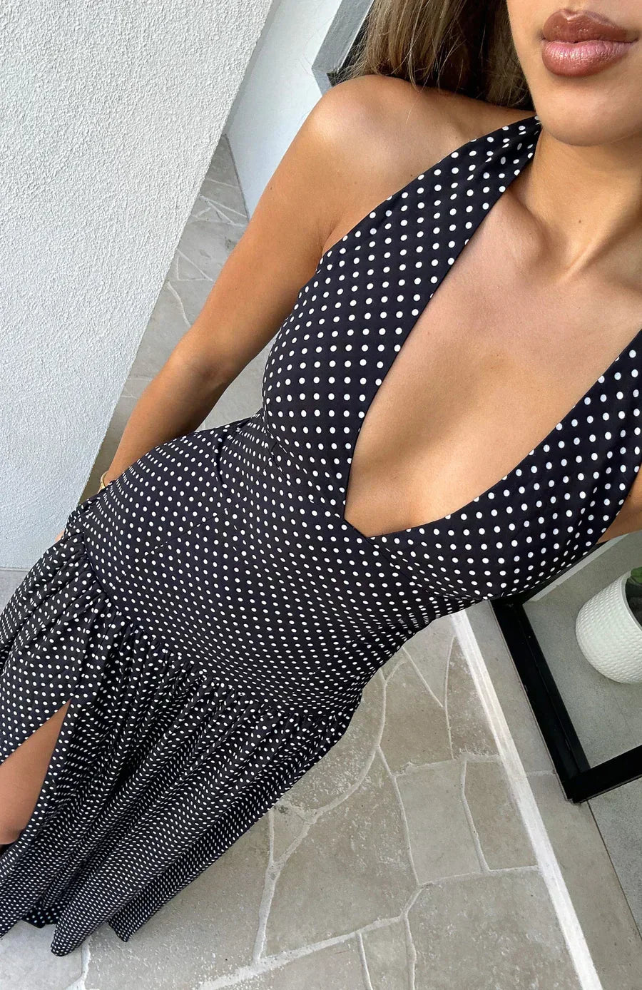 Robe longue femme noire à pois, col plongeant, en tissu léger avec une coupe fluide et des manches courtes.