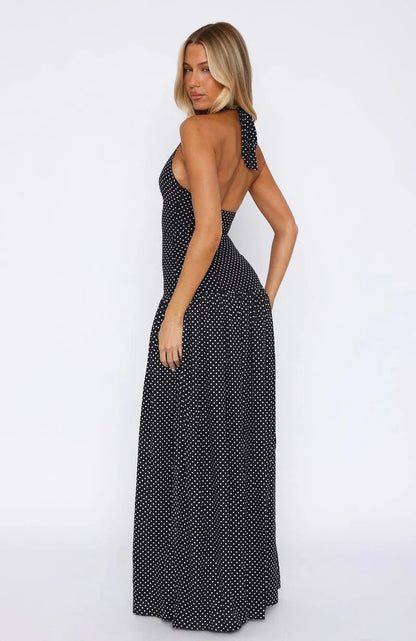 Robe longue noire à pois, col plongeant, en tissu léger, avec un design fluide et manches courtes pour un look élégant.