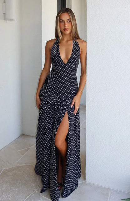 Robe longue femme noire à pois avec col plongeant, en tissu léger, offrant une coupe fluide et des manches courtes.